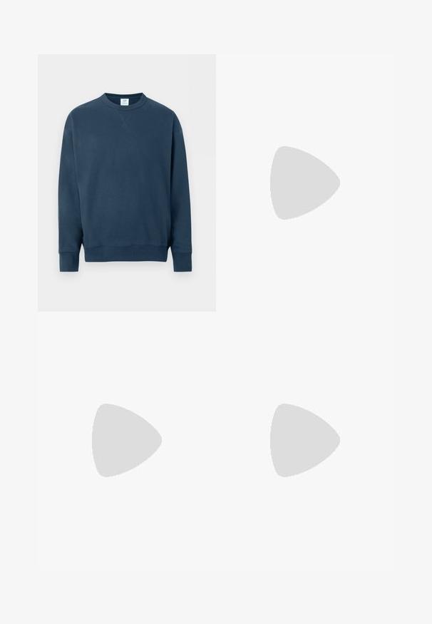 Sweat-shirt bleu marine à col rond, manches longues, poignets et ourlet côtelés, avec un petit détail en V cousu sous le col.; Chemise boutonnée en bleu clair avec un motif texturé, dotée d'un col, de manches longues et d'une poche poitrine unique.; Pantalon droit en velours beige, avec une texture côtelée, un design à cinq poches et une fermeture à boutons.; Baskets blanches avec des accents noirs et gris, présentant un embout texturé gris, une semelle en caoutchouc noir et des lacets plats blancs. Design épuré, style minimaliste.