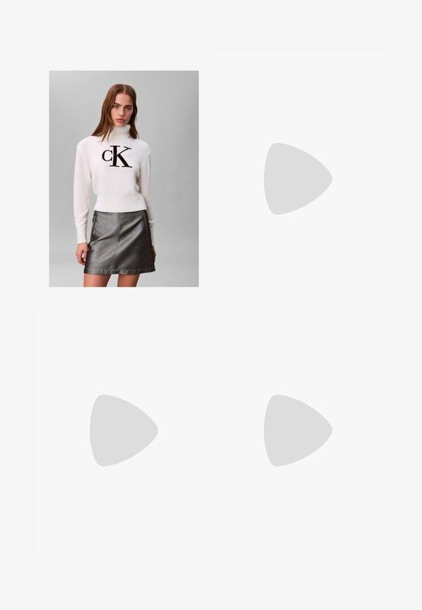 Mujer joven con un suéter blanco de cuello alto con el logo negro de "CK" y una falda de cuero metálica gris oscuro, posando frente a un fondo liso.; Jeans de mezclilla negros de tiro alto con piernas rectas, diseño de cinco bolsillos, cierre frontal con botón y detalles de costura mínimos.; Bota de tobillo de cuero negra con punta afilada, tacón cuadrado y una correa con un detalle de logo metálico. Textura suave y diseño minimalista.; Pendientes aros de metal plateado con un diseño texturizado, que cuentan con un pequeño respaldo de clip y una marca en uno de los aros. Forma redondeada con un acabado pulido.