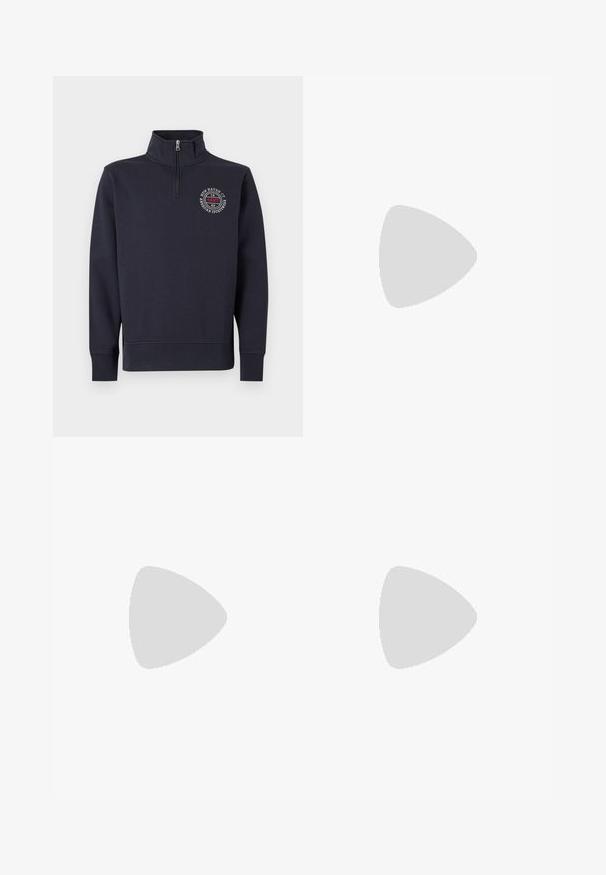 Pull-over en polaire bleu marine avec col montant, fermeture éclair et logo sur la poitrine avant présentant un design circulaire et du texte. Texture lisse, poignets côtelés.; T-shirt à col rond à manches courtes gris foncé avec un petit écusson logo Tommy Jeans sur la poitrine gauche.; Jean en denim bleu avec une coupe droite, comportant cinq poches, une fermeture à bouton et une finition délavée. La texture est lisse avec des coutures visibles.; Mocassin en daim marron avec semelle blanche et détail métallique, flottant au-dessus d'un tapis clair à côté d'un meuble rond marron brillant.