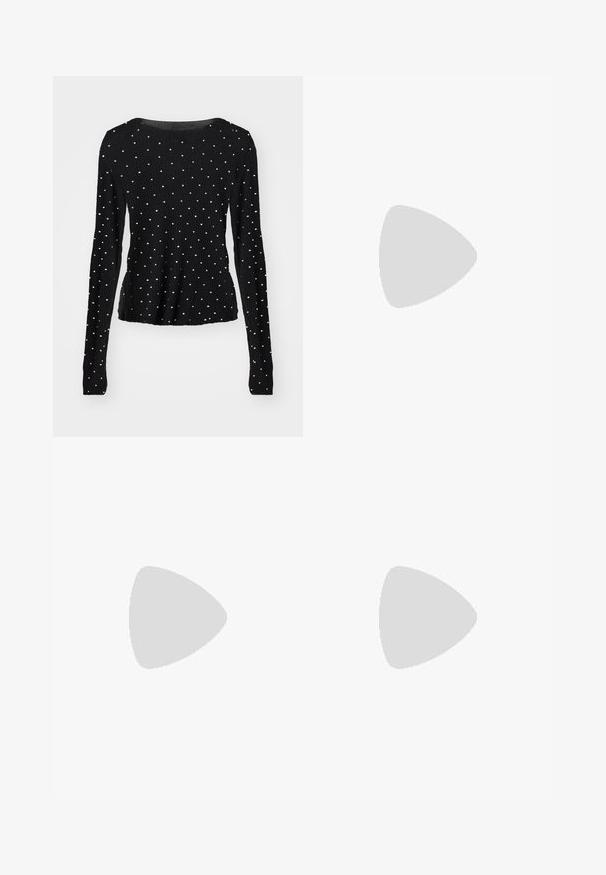 Haut noir à manches longues avec une texture côtelée, présentant des accents en clous argentés répartis de manière uniforme sur le tissu. Encolure ronde.; Jean en denim gris foncé délavé avec légère usure, style à cinq poches et jambes évasées.; Jambes portant des leggings côtelés foncés associés à des ballerines noires avec de petits détails en nœud sur fond blanc.; Sac à main en tissu noir, de forme arrondie, orné de clous métalliques ronds en argent disposés en motif, et d'un accent en tissu noué.