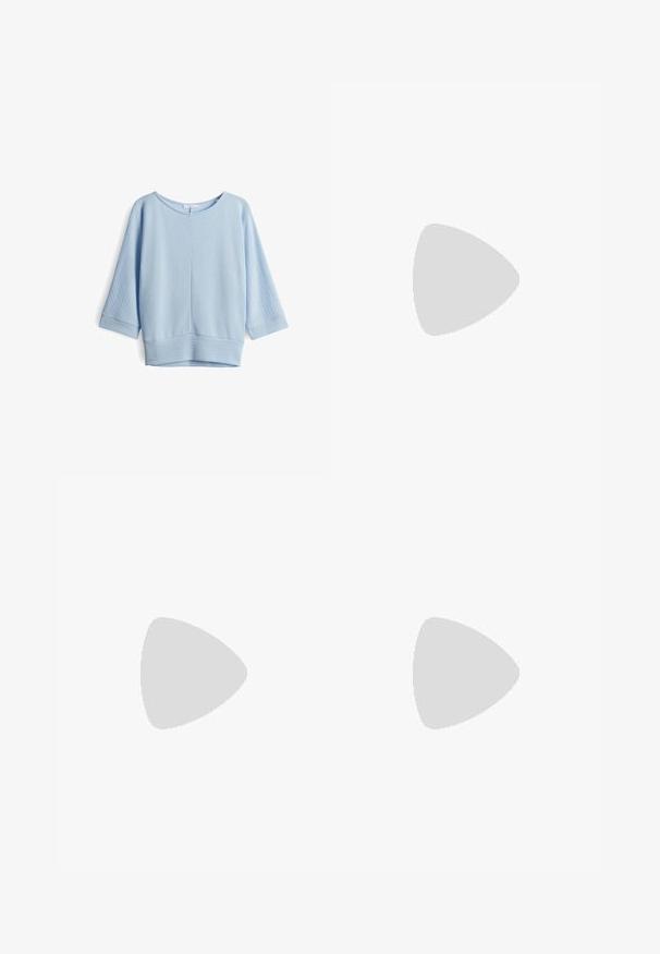 Helles blauer Pullover aus einem strukturierten Stoff, mit Dreiviertelärmeln und einem weiten Rundhalsausschnitt, sowie einem festen Bündchen am unteren Ende.; Jeans-Bleistiftrock in Dunkelblau mit figurbetontem Schnitt, Taillenbund mit Gürtelschlaufen und sichtbaren Nähten an den Nähten und Taschen.; Schwarzer Crocs-Clog mit Belüftungslöchern und Riemen, schwebend über einem beigen gewebten Teppich, einem Couchtisch aus Holz mit Büchern und einem beigen Sofa im Hintergrund.; Schwarze übergroße Sonnenbrille mit Katzenaugenform, dunkel getönten Gläsern und glänzendem Kunststoffrahmen. Verfügt über dicke Bügel für Unterstützung.