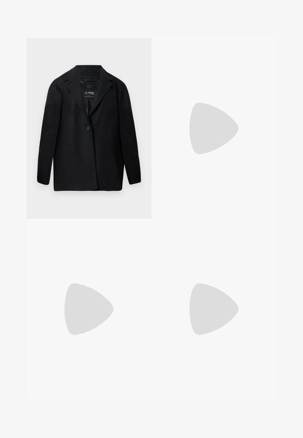 Blazer noir en tissu recyclé, avec un col cranté, une fermeture à un bouton et des manches longues. Surface texturée avec des particules de peluches visibles.; Haut rouge sans manches avec un col montant, confectionné dans un tissu lisse. Présente une coupe décontractée et un design minimaliste. Aucun motif ni accent.; Pantalon noir ajusté avec une coupe droite, présentant des plis avant, une texture lisse et des passants de ceinture. Pas de poches visibles.; Chaussure noire à talon haut avec bout pointu et logo doré, posée sur une surface réfléchissante près d'un organiseur de dossiers en fil chromé contenant des documents.