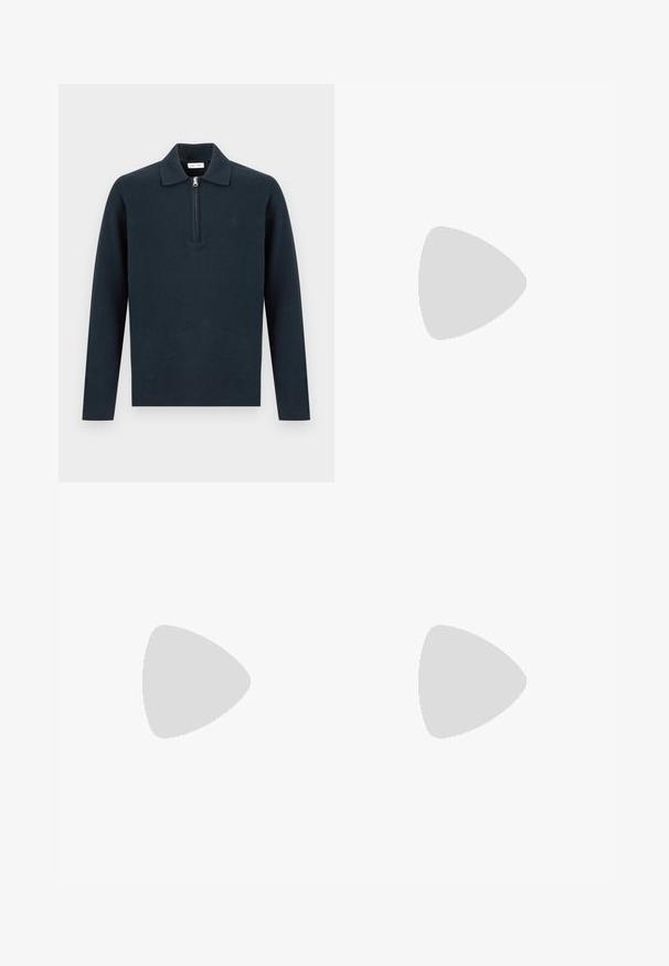 Pull-over à manches longues bleu marine foncé avec un col et une fermeture éclair à moitié zip sur le devant, présenté sur un fond clair uni.; Polo beige à manches courtes avec une texture côtelée verticale et une courte fermeture éclair devant sous le col.; Pantalon beige clair droit avec fermeture par bouton et fermeture éclair ainsi que passants pour ceinture, présenté sur un fond blanc uni.; Mocassin en suède marron clair avec semelle noire, posé sur un tapis beige devant une table circulaire marron réfléchissante contre un mur en bois.