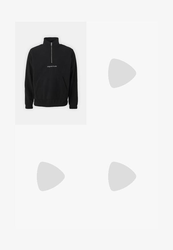 Pull léger en polaire noir avec un col haut et un zip à mi-hauteur à l'avant. Présente une poche kangourou à l'avant et un logo brodé "Originals Studio".; T-shirt gris clair à manches courtes avec un col rond et une petite poche poitrine sur le côté gauche avec une étiquette rouge.; Pantalon de survêtement à taille élastique bleu-gris avec cordon de serrage ajustable et jambes droites, présenté sur un fond blanc.; Chaussure noire à lacets avec semelle épaisse à nervures flottant au-dessus d'un tapis beige, table ronde moderne marron en arrière-plan dans une pièce à éclairage doux.