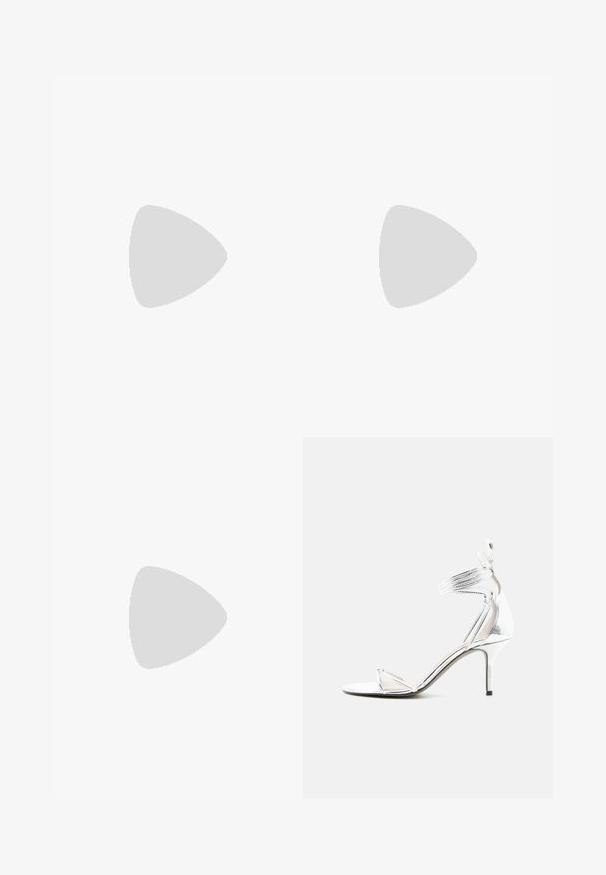 Musthave musta pikkade varrukatega jumpsuit, millel on ruudukujuline kaelus, kehas kokkuvolditud disain ja ja kitsa säärega, valmistatud venivast kangast.; Hõbedane kõrge kontsaga sandaal õhukeste rihmade, pahklu ümbermähise ja peene kontsaga sirgel valgel taustal.; Väike hõbedane metallist õlalõikaja ümarate, volditud detailidega ja sulguriga, millel on kaks hõbedast palli.; Hõbedane käevõru, millel on mitmed selged, ümmargused ja ruudukujulised kristallid, mis on paigutatud sümmeetrilisse mustrisse ning millel on põhipaneel.