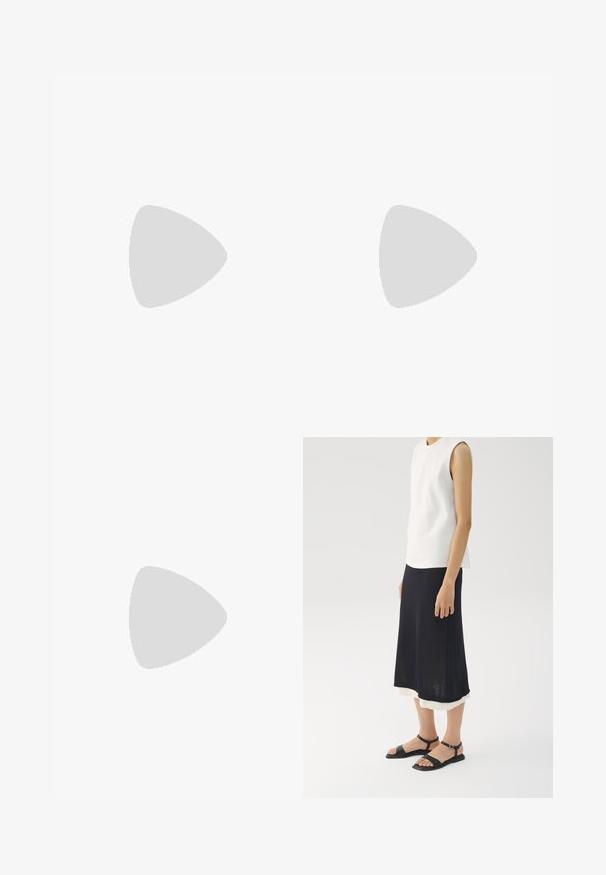 Schwarzer und cremefarbener gemusterter Jumpsuit mit kurzen Ärmeln, V-Ausschnitt und elastischem Bund. Der Stoff wirkt leicht und hat ein fließendes Design.; Ärmelloses weißes Oberteil, schwarzer knielanger Rock mit einer hellen Unterlage und schwarze flache Sandalen mit Knöchelriemen und quadratischen Zehen.; Braune Schildpatt-Sonnenbrille mit einer Vintage-Cat-Eye-Form und braunen Gläsern. Verfügt über gebogene Bügel mit roten Akzenten.; Goldfarbene Creolen mit einer glatten, polierten Oberfläche. Sie haben eine halbkreisförmige Form und einen sicheren Stiftverschluss.