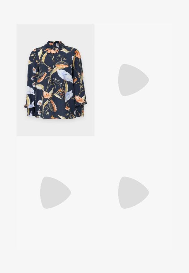 Langærmet mørkeblå bluse med blomsterprint i orange, hvid og grøn. Har en sammensnøret hals og elastiske manchetter. Blød stofstruktur.; Lyseblå denimjeans har en lige ben design, fem lomme stil og en knaplukning. Stoffet har en falmet tekstur.; Sort hælsandal med krydsede stropper med sølvøjer og en rund spænde, placeret på tekstureret fortov nær flisevæg.; Kremfarvet håndtaske i halvmåneform med kort håndtag, der har en metaldetalje i guldton og lynlåslukning på siden.
