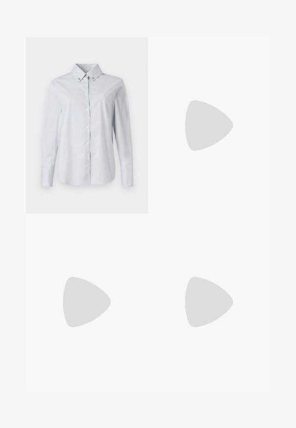 Hellblau-weiß gestreifte Button-Down-Bluse mit spitzem Kragen, langen Ärmeln und einem kleinen gestickten Logo auf der Brust.; Blaue gemusterte Hose mit einem rautenförmigen Steppdesign und kleinen dekorativen Perlen, einem elastischen Bund und einem Knopfverschluss.; Braune Leder-Calvin Klein Absatzpantolette, die über einem Holzboden mit verschwommenem grünem Pflanzen- und Wandhintergrund schwebt.; Beige Leder-Crossbody-Tasche mit gestepptem Muster, rechteckiger Form, dünnem Trageriemen und silberner Hardware, getragen von einer Person in einer schwarzen Jacke.