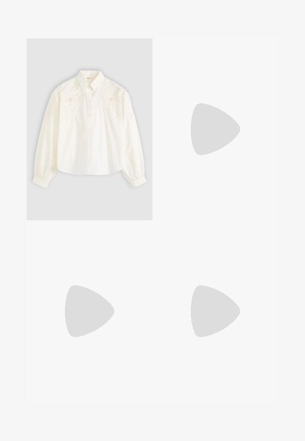 Witte katoenen blouse met lange pofmouwen, voorzien van ingewikkelde bloemenborduursels op de schouders, klassieke kraag en knoopsluiting aan de voorkant.; Lichtblauwe denim short met afgeknipte pijpen en rafelige zoom, vijf zakken en een knoopsluiting. De stof is zacht en heeft een licht versleten uitstraling.; Cowboy enkelboot in bruin en wit nepbont, met een spitse neus en een gemiddelde blokhak. Voorzien van zij-elastische panelen voor gemakkelijk aan- en uittrekken.; Set glanzende gouden creolen met dikke ronde schakels op een effen lichtgrijze achtergrond.