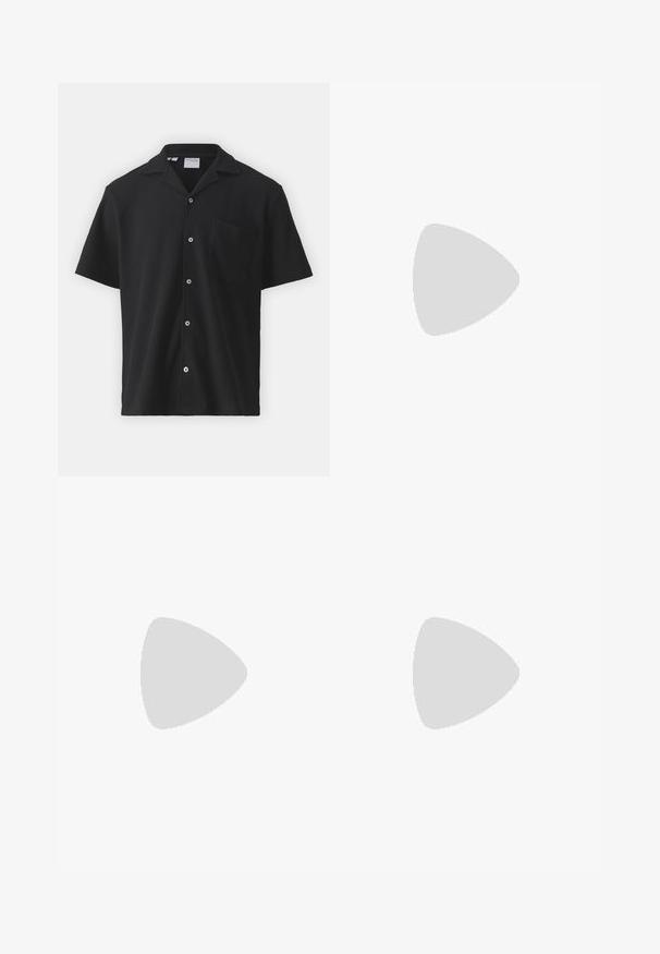 Zwart shirt met korte mouwen, gemaakt van textuurstof met een subtiel geribbeld patroon, voorzien van een knopenpat en een borstzak.; Zwarte katoen salopettes met verstelbare banden, een voorkantzak met logo patch en twee zijzakken in een relaxte pasvorm.; Witte leren sneaker met een gestructureerde zwarte Swoosh, platte veters en een rubberen zool met een geribbeld patroon. "AIR" is in de hak geperst.; Zilveren ketting met in elkaar grijpende schakels, een gladde textuur en een uniforme rechthoekige vorm. Veilige sluiting.