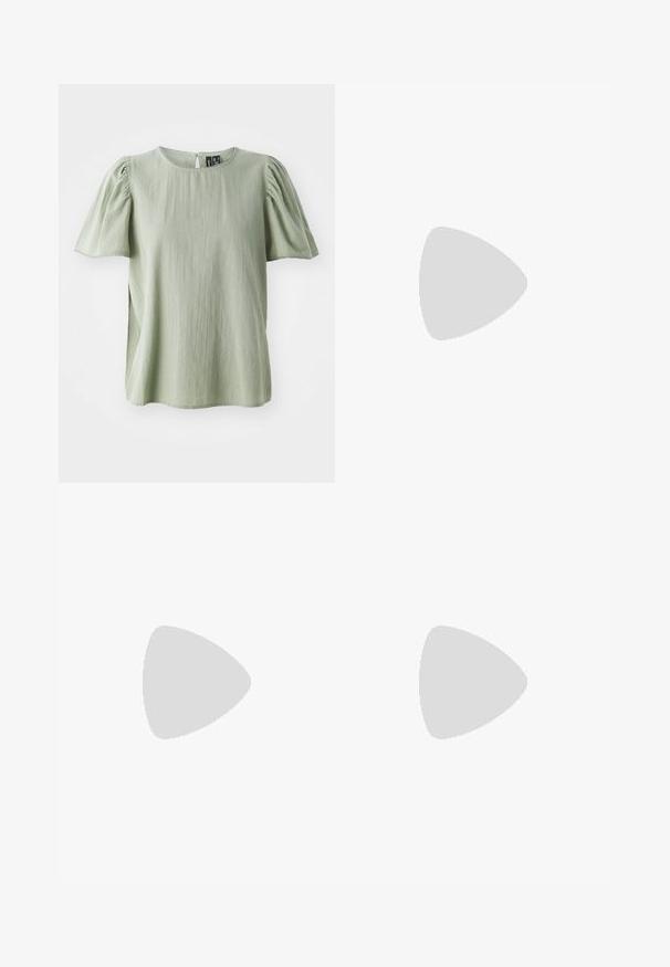 Chemisier vert à manches courtes avec encolure ronde, manches légèrement bouffantes et délicate finition sur l'encolure et les bords des manches.; Shorts taille haute jaune clair avec broderie florale et un motif œillet subtil, coupe cintrée et longueur mi-cuisse.; Chaussure plate slingback en cuir marron foncé avec bout carré, texture crocodile et boucle argentée sur la bride.; Petit sac à main texturé doré avec poignée supérieure et fermoir décoratif en forme de nœud orné de petits cristaux.