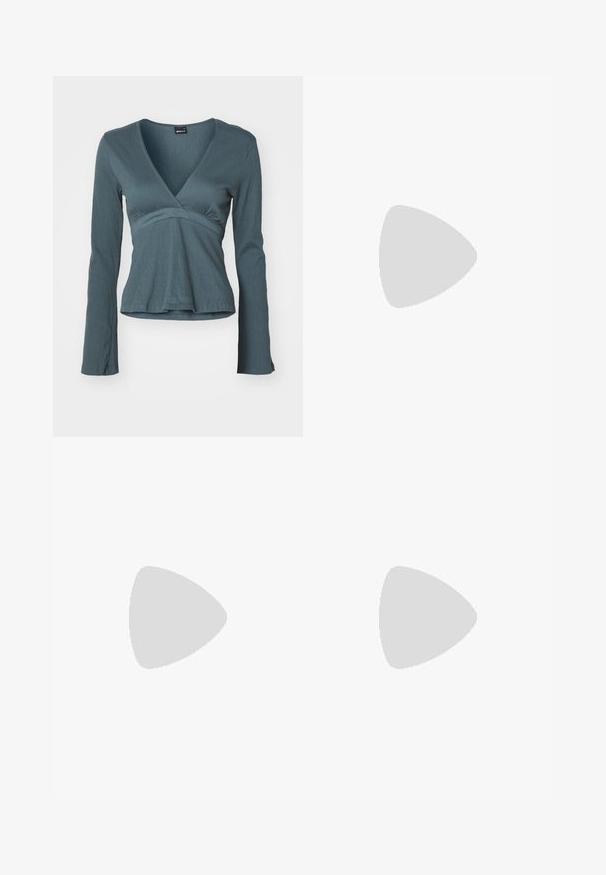 Langærmet indpakningsbluse i dyb teal med en struktureret overflade, der har en V-halsudskæring og en tætsiddende talje, som svagt flares ud ved kanten.; Flared jeans i lys beige bomuldsdenim med høj talje, fem-lomme design og klassisk metallukning med lynlås.; Hvide hælede sandaler med spids tå, justerbar ankelrem og en kraftig firkantet hæl. Glat tekstur med minimale syninger.; Sølvmetal øreringe med et bølgende, skulpturelt design, der har en poleret overflade og uregelmæssige former, hvilket fremhæver en moderne æstetik.