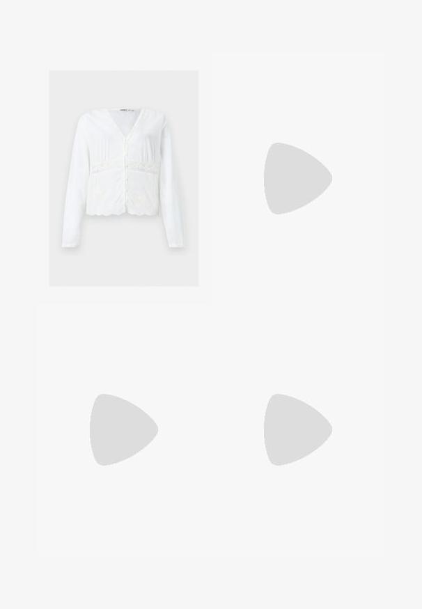 Blouse blanche à manches longues boutonnée, col en V, détails en dentelle autour de la taille et ourlet festonné.; Mini-jupe rose clair texturée avec une large ceinture et un détail de tissu froncé sur un fond uni.; Jambes portant des leggings côtelés foncés associés à des ballerines noires avec de petits détails en nœud sur fond blanc.; Sac à main rectangulaire rose pâle avec double poignée, nœud décoratif, œillets métalliques et petit charm en forme de cœur sur un fond uni.