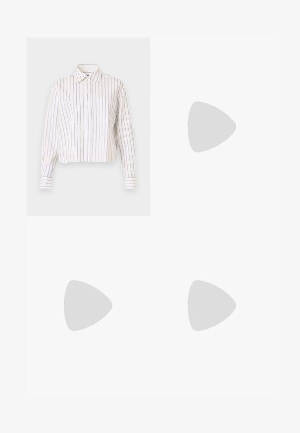 Chemise rayée blanche avec de fines rayures brunes. Elle a un col pointu, des manches longues et une poche poitrine. Longueur courte.; Pantalons larges blancs en tissu léger, présentant une texture lisse, des lignes épurées et une taille haute.; Chaussure plate en cuir noir avec bout pointu et logo CK doré sur la bride, posée sur un tapis beige près d'une table ronde couleur ambre brun.; Sac à bandoulière blanc Calvin Klein avec longues poignées, forme rectangulaire, fermeture éclair et charm logo décoratif suspendu près de la poignée.