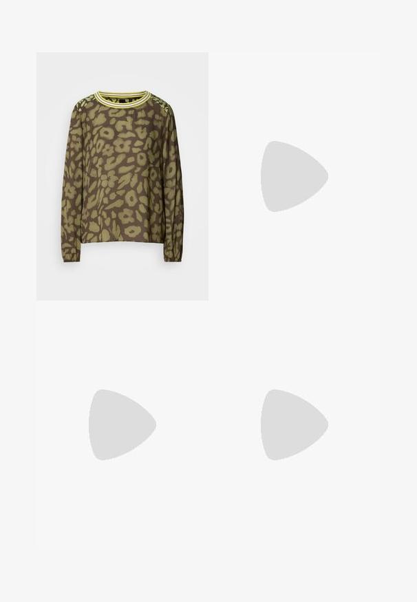 Haut marron à manches longues avec un motif floral abstrait vert, col rond avec des rayures jaunes et poignets élastiques.; Jean large bleu clair en denim, doté d'une taille haute, de cinq poches et de légères traces de frottement à l'avant pour une texture.; Baskets en daim beige à lacets flottant au-dessus d'un sol en carrelage en bois, avec de la verdure et un mur gris en arrière-plan.; Bracelet en métal avec des bandes entrelacées en argent et en or, finition lisse et polie. Détail de nœud notable au centre.