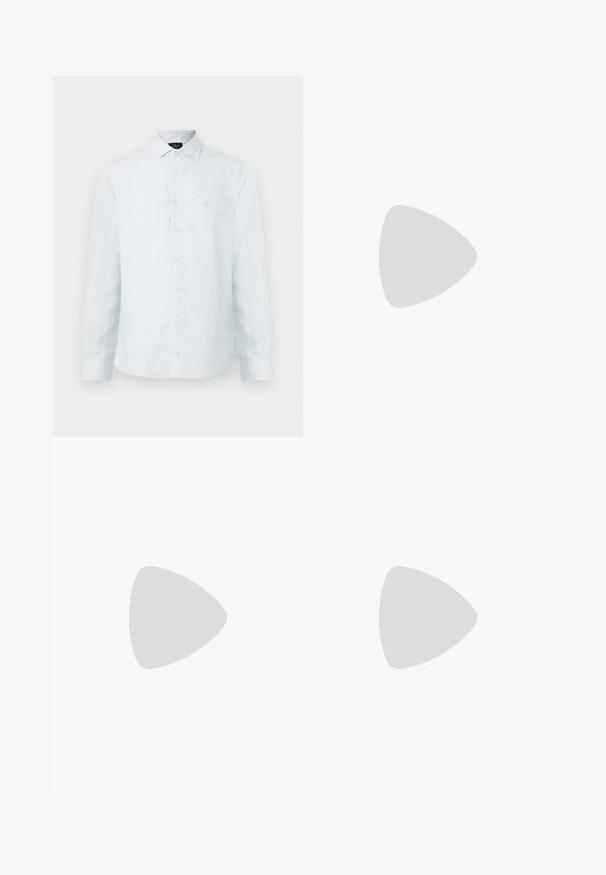 Chemise à boutons pour homme en bleu clair avec des rayures verticales blanches, col classique, manches longues et logo subtil sur la poitrine.; Pantalon en coton beige avec une coupe droite, présentant une fermeture à bouton et des plis sur le devant pour plus de détails.; Chaussure mocassin en cuir noir suspendue au-dessus d’un tapis beige avec du mobilier moderne couleur ambre en arrière-plan.; Serviette en cuir noir texturé avec poignées supérieures et bandoulière amovible, montrant un petit logo avant sur fond gris neutre.