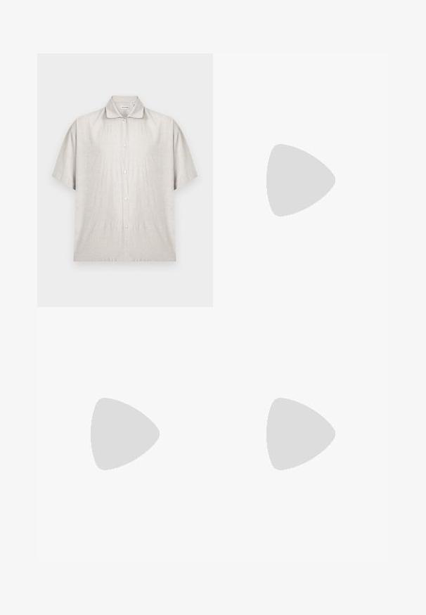 Chemise beige clair à manches courtes en tissu doux. Elle présente un col classique et une patte de boutonnage avec sept boutons.; Short blanc en coton avec taille élastique et cordon, longueur genou avec une coupe décontractée et ample.; Sandale claquette en cuir marron avec une semelle noire suspendue au-dessus d'un tapis beige dans un intérieur aux tons neutres.; Sac fourre-tout en toile avec longues anses noires, bordure noire en bas et poche avant avec logo "Les Deux" en écriture noire.
