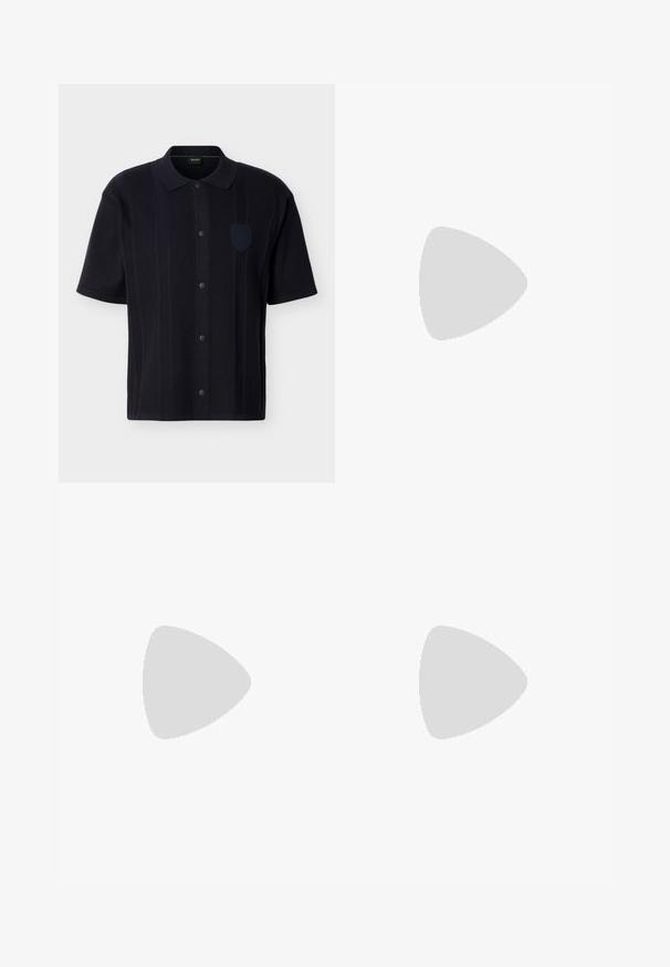 Chemise noire à manches courtes avec des rayures verticales texturées, un col et un petit badge sur la poitrine côté gauche.; Pantalon large bleu marine foncé avec passants pour ceinture, fermeture à bouton et zip à l'avant, et poches latérales, présenté sur fond blanc.; Chaussures en cuir noir à lacets avec une texture lisse, un bout arrondi et des détails de couture discrets. Présentent une languette rouge à l'arrière.; Ceinture en cuir noir enroulée avec une boucle métallique argentée présentant un design stylisé double "B" sur fond blanc.