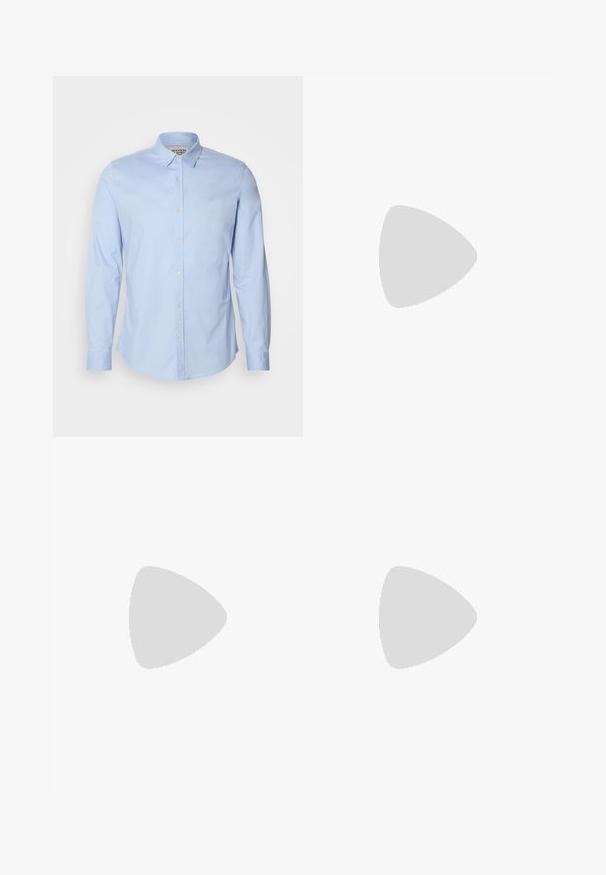 Chemise à manches longues bleu clair en coton, dotée d'un col boutonné, de boutons sur le devant et d'un logo brodé subtilement sur la poitrine.; Pantalons gris fuselés en tissu texturé, avec poches avant et une fermeture à un bouton à la taille. Lavable en machine.; Chaussure Oxford en daim brun clair avec détails brogués, flottant au-dessus d'un tapis beige texturé devant un canapé beige.; Cravate en soie beige avec un motif de rayures diagonales, un mouchoir assorti et une épingle à fleurs en tissu, le tout présentant des textures douces.