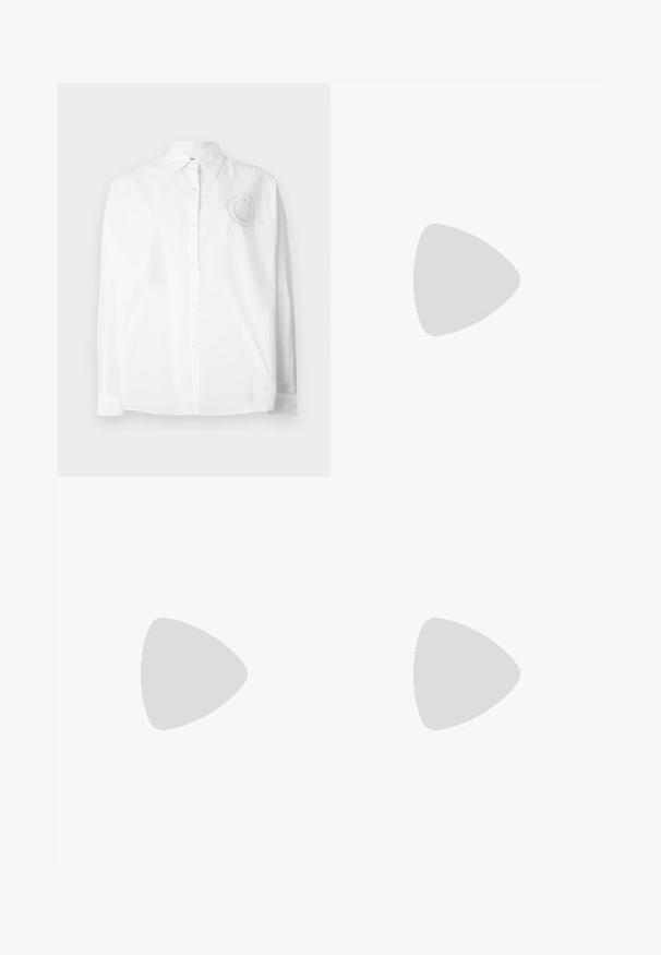 Chemise blanche boutonnée avec un col classique, des manches longues et un motif de visage souriant brodé sur le côté gauche de la poitrine.; Jean en denim bleu foncé taille haute avec une légère évasement en bas, bouton frontal, fermeture éclair et poches avant et arrière.; Mule à talon haut en cuir verni noir avec bout ouvert et breloques argentées décoratives comprenant une fleur et un cadenas sur la bride avant.; Sac d'épaule noir avec sangle réglable, fermeture éclair et petit logo crocodile argenté au centre devant.