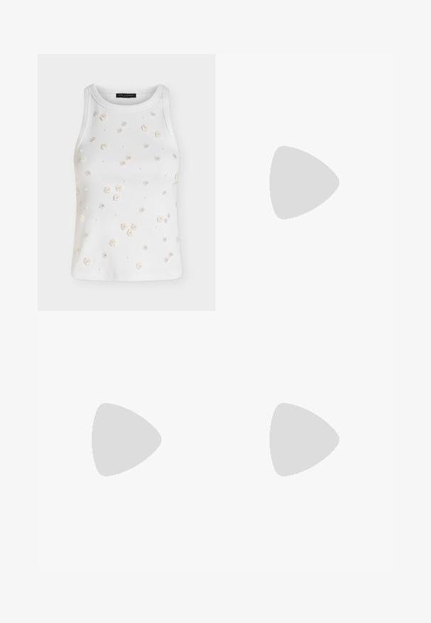 Top blanco sin mangas de canalé decorado con pequeñas aplicaciones florales en color crema y adornos de cuentas dispersos por el frente.; Vaqueros acampanados con un diseño bi-tono en paneles de denim azul oscuro y claro, cierre frontal con botón y estilo clásico de bolsillos.; Zapato plano de charol negro con punta cuadrada, correa de tobillo con herrajes de plata y suela plana. Textura suave con diseño minimalista.; Bolso de mano de ante azul oscuro con costuras blancas, asa recortada, correa de hombro estampada y largas borlas de flecos en ambos lados.