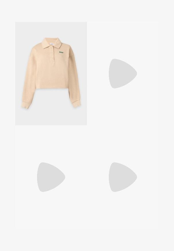 Polo beige à manches longues et court avec col, trois boutons et petit logo vert Lacoste sur le côté gauche de la poitrine.; Jupe noire avec une large ceinture et une partie inférieure plissée, étalée à plat sur un fond blanc.; Baskets volumineuses en blanc, gris et argent métallique avec des panneaux texturés. Comprend une épaisse semelle en caoutchouc noir et un design d'overlay distinctif.; Petit sac à main beige avec deux poignées courtes, une longue bandoulière réglable et un logo crocodile à l'avant.