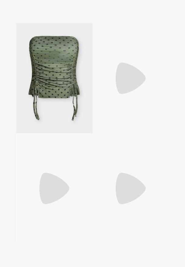 Crop top λαδί χωρίς τιράντες με μαύρες πουά, ραμμένες πλευρές και ρυθμιζόμενα κορδόνια στο κάτω μέρος.; Ανοιχτό μπλε τζιν παντελόνι με φουσκωτά μπατζάκια, μέση μεσαίου ύψους, πέντε τσέπες και διακριτική ξεθώριασμα. Διαθέτει ραφές διακοσμητικές κοντά στις τσέπες.; Μαύρο σουέτ αθλητικό παπούτσι με λευκές τρεις λωρίδες, χρυσό λογότυπο και καφέ καουτσούκ σόλα. Διαθέτει χαμηλού προφίλ σχέδιο με κορδόνια.; Μικρή μαύρη γυαλιστερή τσάντα με δύο μακριές λαβές και λεπτομέρειες με ρυθμιζόμενο κορδόνι στο πλάι σε απλό ανοιχτό φόντο.