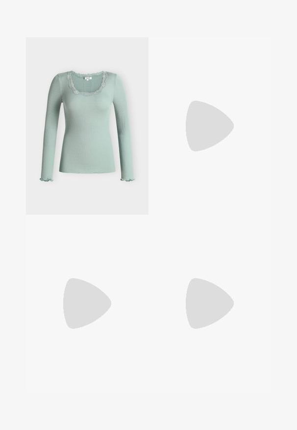 Hellgrünes, geripptes Langarm-Top mit Spitzenbesatz am quadratischen Ausschnitt und Rüschen an den Ärmelsäumen.; Schwarze weit geschnittene Jeans mit grünen Akzenten, aus Jeansstoff, mit hoher Taille, vorderen Taschen und einem Metallknopfverschluss.; Schwarzer Slingback-Schuh aus Leder mit spitz zulaufender Zehenpartie, versehen mit glänzendem Akzent auf der Vorderkappe und mittelhohem Absatz. Offenes Seitendesign.; Schwarze Schultertasche aus Lackleder mit silberner Schnalle und silbernem Kettenriemen, auf hellem einfarbigen Hintergrund präsentiert.
