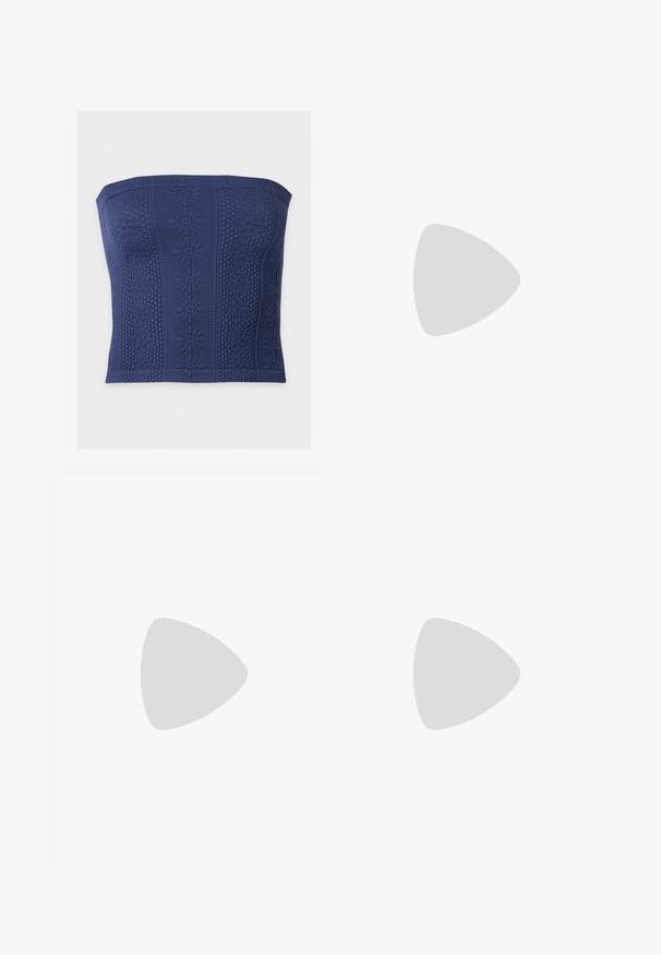 Mørkeblå stropløs top med et tekstureret blomstermønster og bikagemønster, med vertikale dekorative striber.; Blå brede jeans i denim med knap og lynlås foran, der har lommer foran og bagpå samt let falming på lårene.; Sorte læder flade sko med spids tå, samling detaljer omkring åbningen, og en sølv spænde accent på den justerbare rem.; Lille sort blank håndtaske med to lange håndtag og snøre-detaljer i siden på en ensfarvet lys baggrund.