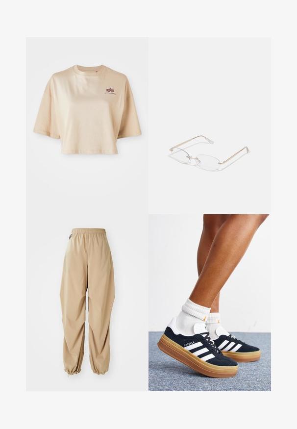 Beige cropped t-shirt lavet af bomuld, med korte ærmer, en rund halsudskæring og et maroon logo grafik på venstre bryst.; Beige letvægtsbukser med elastisk talje, tapered manchetter og en glat tekstur, der har en afslappet pasform og ingen synlige mønstre eller udsmykninger.; Ben iført hvide sokker og sorte Adidas Gazelle sneakers med hvide striber og tykke brune såler på et gråt tæppe.; Guldmetal briller med ovale linser, slanke arme og klare næsepuder. Har subtile hængsel accenter og gennemsigtige linser.