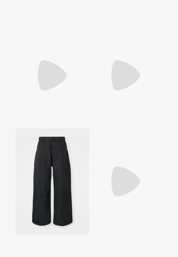 Korte mouwen overhemd met knopen in levendig oranje en zwart met een golvend patroon. Gemaakt van gladde stof, met witte knopen en een kraag.; Zwarte wijde broek van canvasmateriaal met een knoopsluiting, voorzien van twee voorzakken en een ontspannen pasvorm.; Zwarte leren slip-on muil met afgeronde neus en lage blokhak op een effen lichte achtergrond.; Ketting met afwisselend zwarte en meerkleurige kralen, met kleine zilveren ringen en een rechthoekige doorzichtige kraalhanger.