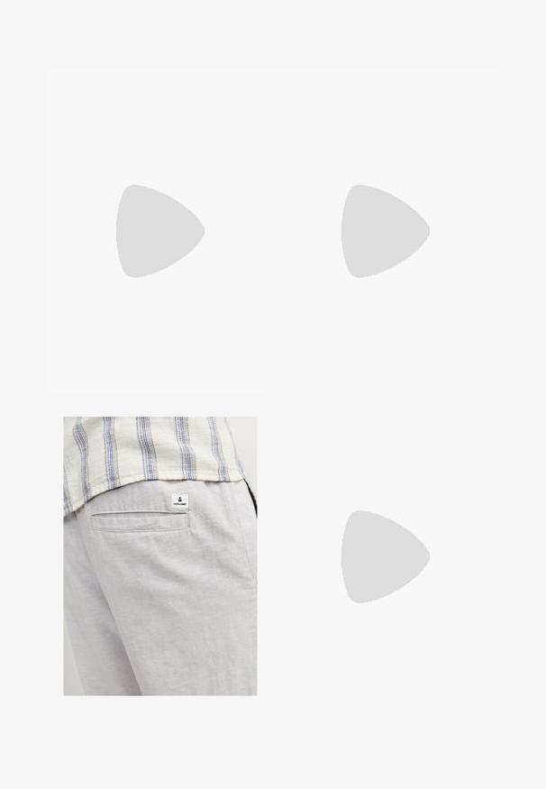 T-shirt blanc à manches courtes avec un motif géométrique jaune sur le haut et les manches, avec une poche poitrine jaune unie sur le côté gauche.; Pantalon en lin gris clair avec une poche arrière et une petite étiquette de marque. Le tissu a une apparence douce et texturée.; Sandale en daim beige pour homme avec deux larges brides, semelle noire et bride de talon réglable avec boucle, présentée sur fond blanc.; Collier en perles blanches avec une forme ronde uniforme, surface lisse et fermoir en métal avec une chaîne d'extension pour une longueur ajustable.
