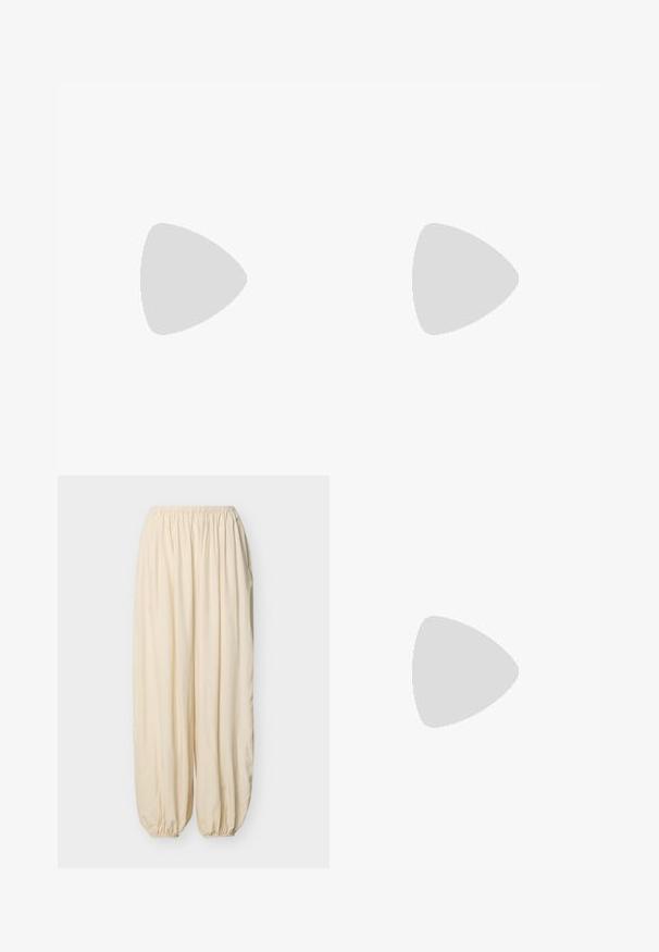Navyblauw t-shirt met korte mouwen en een ronde halslijn, met pofmouwen en een ontspannen pasvorm. Zachte stof met een gladde textuur.; Losse, roomkleurige broek met een elastische tailleband en gerimpelde elastische boorden op een effen lichte achtergrond.; Zwarte slide-sandaal met twee olijfgroene bandjes en een zilveren gesp, rustend op grijze asfalt bij een betegelde stoepmuur.; Bruine leren schoudertas met verstelbare riem, witte stiksels, geperst patroon en grote ronde gouden gesp op de voorflap.