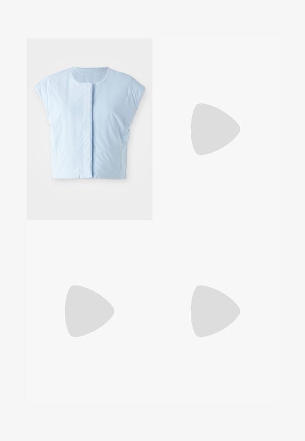 Lichtblauw cropped top gemaakt van gladde stof, met een ronde halslijn, korte mouwen, knoopsluiting aan de voorkant en subtiele naaddetails.; Marineblauw gestreepte shirt met kraag, borstzak en lange mouwen. Gemaakt van een gladde, glanzende stof met een losse pasvorm.; Marineblauwe, middellange rok met een elastische tailleband, voorzien van twee zijcargo pockets en een minimale logo-opdruk. Gladde stoftextuur.; Witte en zilveren Nike hardloopschoen met een beige swoosh-logo, getoond zwevend boven een stenen oppervlak met een onscherpe grijze muur op de achtergrond.