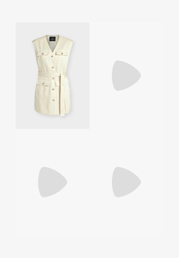 Mouwloos crèmekleurig vest met V-hals, vier knoopklepzakken, gouden knopen aan de voorkant en een bijpassende stoffen riem gestrikt in de taille.; Zwarte geribbelde gebreide jurk met een off-the-shoulder halslijn, lange mouwen en een aansluitende silhouet dat tot halverwege de kuit reikt.; Zwarte damespump met lage hak, puntige neus, smalle, uitlopende kittenhak en een gladde matte afwerking, zijaanzicht.; Jonge vrouw in blauwe satijnen blouse en broek staat met gekruiste armen en houdt een zwarte handtas met gouden kettingriem tegen een beige muur.