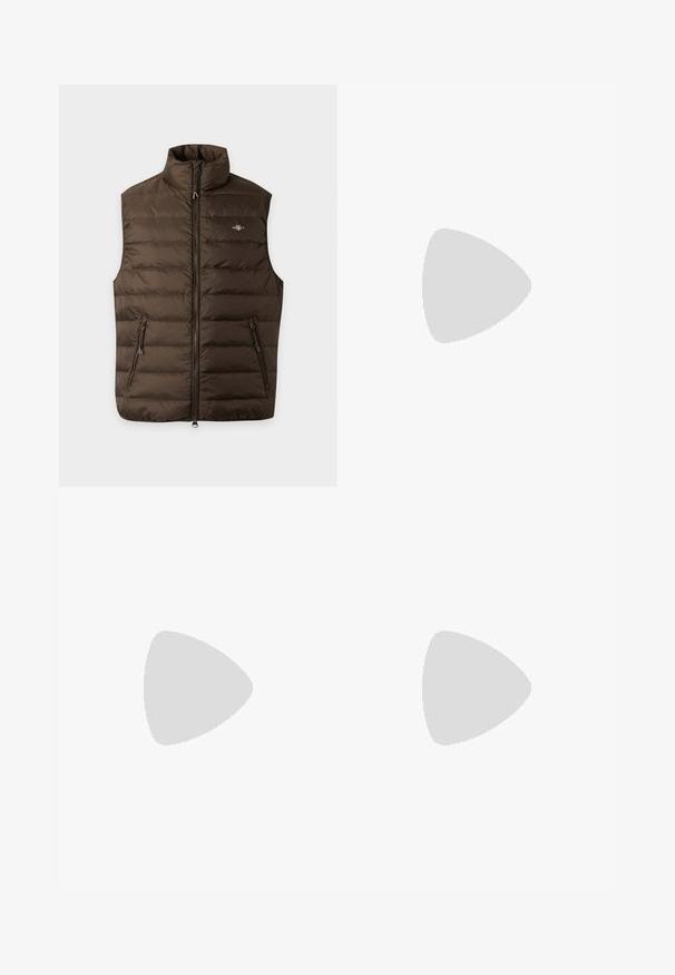 Veste matelassée marron sans manches avec col montant, fermeture éclair intégrale devant, deux poches latérales zippées et petit logo poitrine sur fond uni.; Pull en maille verte avec un motif en torsades, col rond, et poignets et ourlet côtelés. Petit logo sur la poitrine.; Jeans en denim à jambes larges de couleur bleu foncé, avec un effet délavé, un design à cinq poches et des coutures robustes. Fermeture à boutons à la taille.; Mocassin en cuir marron avec un détail à franges sur le dessus et une semelle épaisse en caoutchouc sur un fond clair uni.