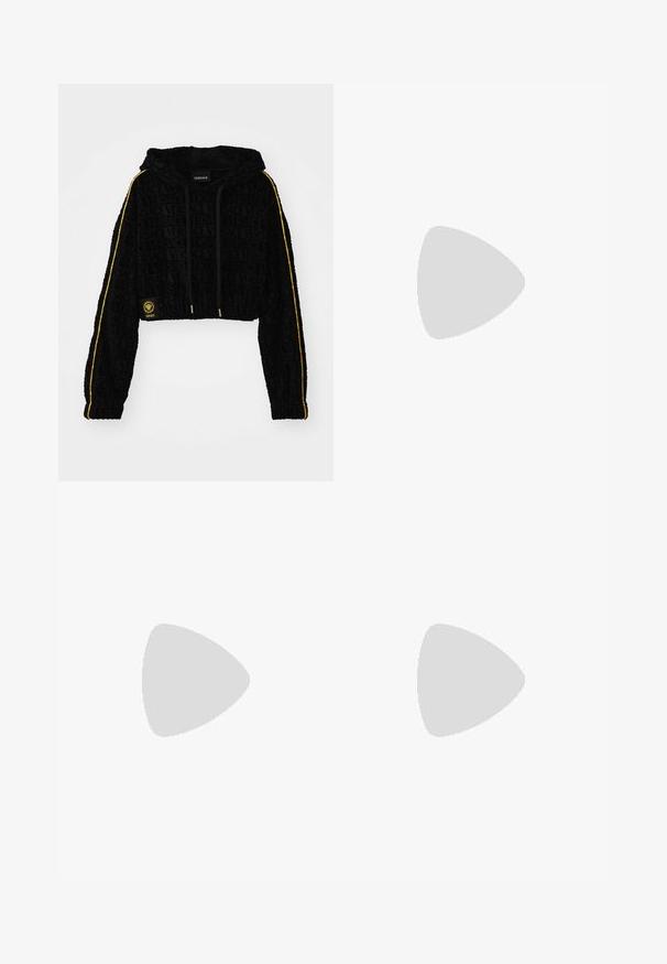 Krótką czarną bluzę z kapturem z wytłoczonym logo 'Versace', żółtymi paskami wzdłuż rękawów i złotymi akcentami. Miękka welurowa faktura.; Bodysuit z długim rękawem w głębokim fioletowym kolorze, wykonany z elastycznego materiału, z wysokim dekoltem i srebrnym logo na piersi.; Czarne spodnie w kształcie dzwonów wykonane z gładkiego materiału, z rozporkami na rękawie związanymi kokardkami dla dodatkowego efektu.; Czarne skórzane botki za kostkę z błyszczącymi akcentami, sznurówkami, złotym detalem klamry oraz grubą podeszwą z teksturowanym bieżnikiem.