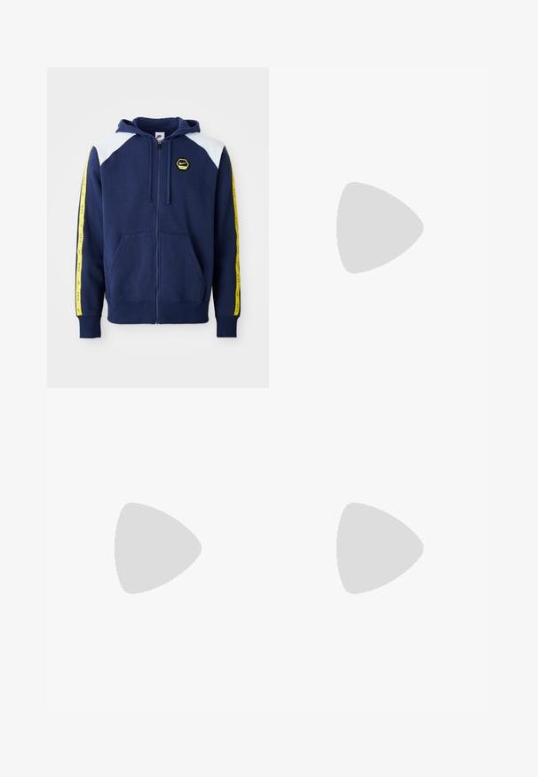 Sudadera con cremallera color marino, con acentos blancos en los hombros, franjas laterales amarillas que presentan el logo y bolsillos delanteros. Fabricada con un tejido suave.; Camiseta de algodón blanca con un gran logo naranja de "NIKE" y texto verde que dice "SPORTSWEAR ENGINEERED" junto con especificaciones adicionales.; Vaqueros de pierna ancha en azul oscuro con un gran gráfico de un perro de caricatura blanco en el bolsillo trasero. Textura de denim, diseño tradicional de cinco bolsillos.; Zapatillas deportivas blancas con superposiciones texturizadas, una suela gruesa y acentos grises. Llevadas con calcetines blancos hasta la pantorrilla y pantalones cortos verdes sobre una superficie azul.