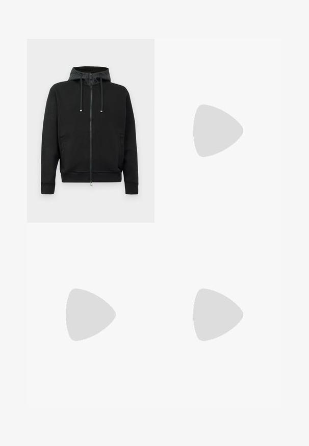 Svart zip-up hettegenser laget av mykt stoff. Har et mønstrete fôr i hetten, snorer og sidelommer. Glatt tekstur, avslappet passform.; Svart bomull T-skjorte med korte ermer, med et fremtredende hvitt "MOSCHINO"-logo over brystet i fet, store bokstaver.; Mørkeblå bukser laget av lett stoff, med rett ben-design, elastisk midje og ingen synlige lommer eller mønstre.; Marineblå ankelhøyde sneakers i semsket skinn med hvit såle, marineblå snøringer, og "Filling Pieces"-logo i gull på siden.