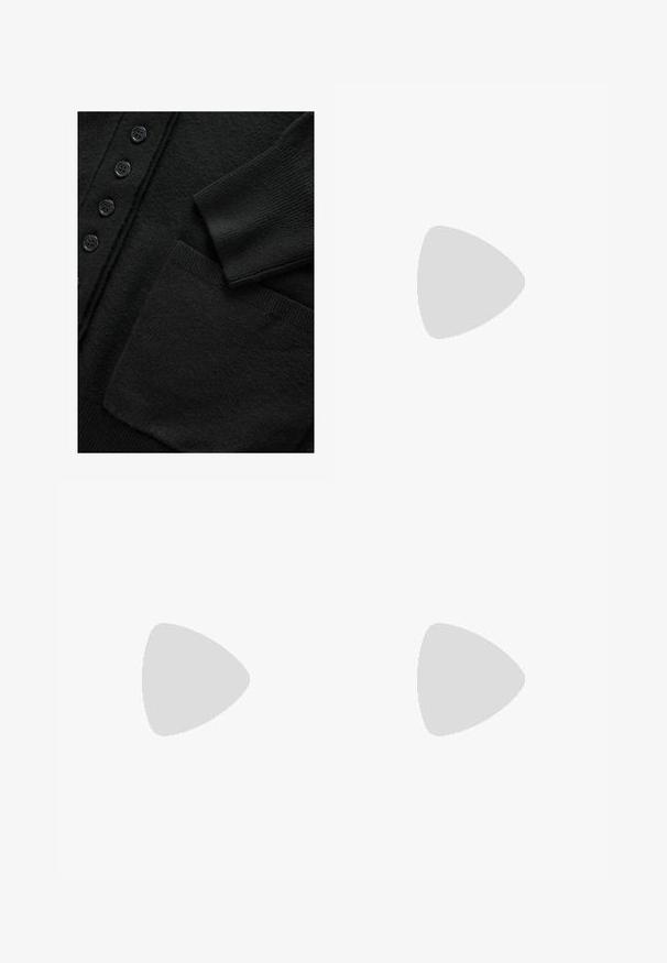 Gilet noir en tricot texturé, doté d'un rang de six boutons noirs et d'une seule poche à patch à l'avant.; Top court sans manches noir en tissu lisse, avec un col rond et un design épuré, simple, sans motifs ni accessoires.; Pantalons larges à rayures rouges et crème, dotés d'une taille élastique avec cordon de serrage, en tissu lisse et au design décontracté.; Escarpins slingback en cuir verni noir avec un bout pointu, un design découpé sur les côtés et un petit talon carré. Texture lisse avec des accents minimaux.