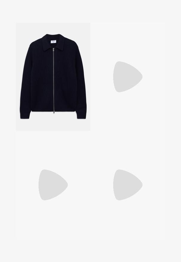 Cardigan cu fermoar, tricotat cu nervuri, de culoare bleumarin, cu guler și mâneci lungi, întins pe un fundal alb.; Tricou cu mânecă scurtă, de culoare albastru deschis, întins pe un fundal alb.; Pantaloni bej, cu talie înaltă, dintr-un material texturat. Prezintă picioare late și două pliseuri frontale pentru structură. Finisaj îngrijit, fără accesorii vizibile.; Mocasini din piele neagră cu o textură netedă, vârf rotund și o curea decorativă peste partea superioară. Toc mic, design minimalist.