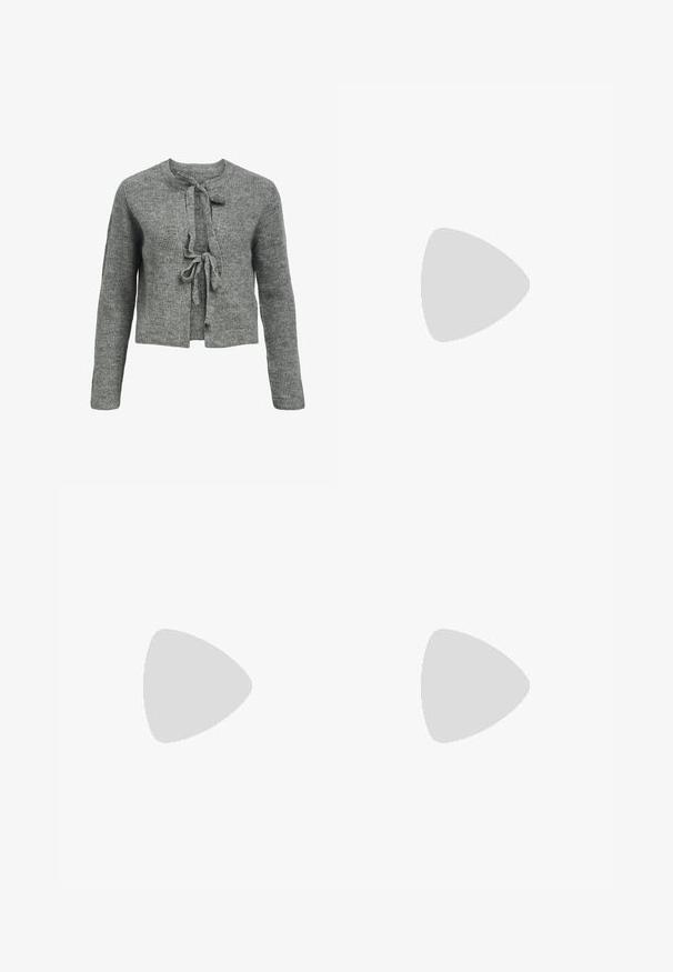 Pull en tricot gris avec un col rond, des manches longues et une fermeture à liens à l'avant. La texture est côtelée, créant une apparence chaleureuse.; Ensemble de bralette en dentelle avec un design floral blanc et son homologue noir. Les deux présentent un décolleté en V et des bretelles larges et détaillées.; Jeans noirs à jambes larges en denim. Présentent une taille haute, cinq poches, une fermeture à bouton à l'avant, et un subtil motif texturé.; Chaussure plate en suede noir avec un bout pointu, ornée d'un détail de nœud en argent décoratif à l'avant, présentant un petit talon.