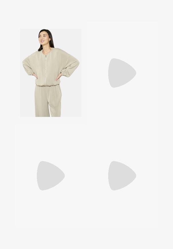 Felpa beige con zip, maniche oversize e scollatura tonda, realizzata in materiale morbido; abbinata a pantaloni coordinati.; T-shirt bianco a maniche corte realizzato in morbido cotone, con scollo a girocollo e forma aderente. Senza motivi o decorazioni visibili.; Pantaloni della tuta grigio chiaro con una vestibilità rilassata, vita elasticizzata, cordoncino e tasche laterali; realizzati in un morbido tessuto testurizzato.; Scarpa da atletica Nike in bianco e rosa chiaro. Presenta una tomaia in rete e una suola curva distintiva con ammortizzazione ad aria visibile.