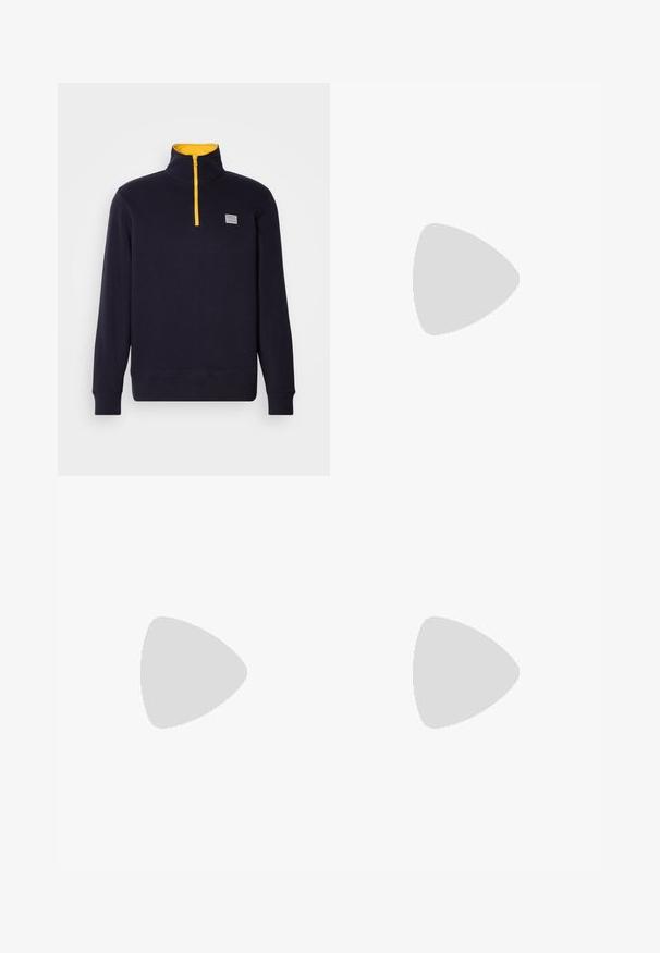 Pulover bleumarin din material moale, cu guler înalt, fermoar galben și o mică etichetă logo pe piept. Manșete și tiv din bumbac ribbed.; Tricou alb din bumbac cu mâneci scurte, având logo-ul "GANT 1949" în nuanțe de bleumarin și roșu, și accente de dungi orizontale roșii și albastre.; Pantaloni din bumbac bej, cu croială dreaptă, dotati cu închidere cu nasture și pliuri în față pentru un plus de detaliu.; Adidași albi cu accente bej, superior din piele netedă, vârf rotunjit și talpă din cauciuc, având un tab superior negru și branding subtil.