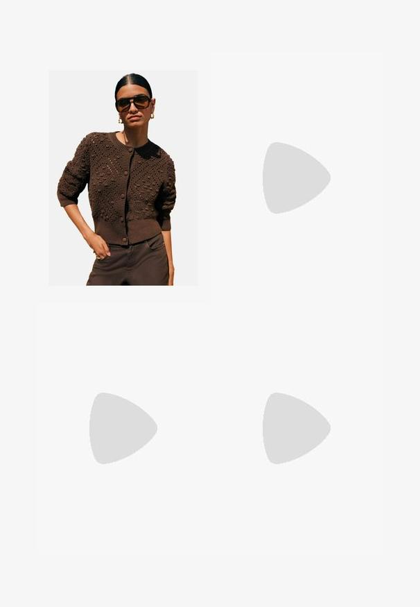 Smeđi pleteni kardigan s teksturiranim uzorcima, okruglim izrezom, rebrastim manžetama i rubom, te kopčanjem na dugme, u kombinaciji s tamnim hlačama.; Bijela košulja s dugim rukavima, ovratnikom, dugmadi sprijeda, dva džepa na prsima, ravnim rubom i lagano proširenim rukavima, izrađena od glatkog materijala.; Smeđi kratki hlače s horizontalnim prugama, s ravnim pojasom i krojem krojenim na mjeri. Kratka dužina s čistim šavovima.; Smeđe nubuk čizme do koljena s ravnim đonom, mekog tekstura i kontrastnim šavovima duž šavova. Dizajn bočne ploče za bolje prilagođavanje.; Okvir okruglih, smeđkastih sunčanih naočala s sjajnim burgundskim okvirom. Uski nositelji s suptilnim brendiranjem. Ravna leća.