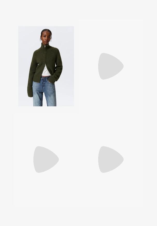 Dunkelgrüner, zuweisbarer Pullover mit geripptem Kragen und Bündchen. Weiche Textur, cropped Design, getragen über einem weißen Oberteil, kombiniert mit hellblauen Jeans.; Schwarzes ärmelloses Crop-Top aus glattem Stoff, mit rundem Ausschnitt und einem klaren, schlichten Design ohne Muster oder Beschläge.; Schwarze Hose mit geradem Schnitt, ausgestattet mit Fronttaschen und Seitenschlitzen am Saum. Hergestellt aus weichem, glattem Stoff. Geeignet für verschiedene Anlässe.; Schwarze flache Sandalen mit glänzender Oberfläche, drei dünnen Riemen und einem runden Hardware-Detail an den Zehen. Elegantes Design mit einem minimalen Absatz.; Rote rechteckige Brille mit schlankem Design. Klare Gläser, leicht durchsichtige Bügel und ein Verlaufseffekt von Rot zu Grau.