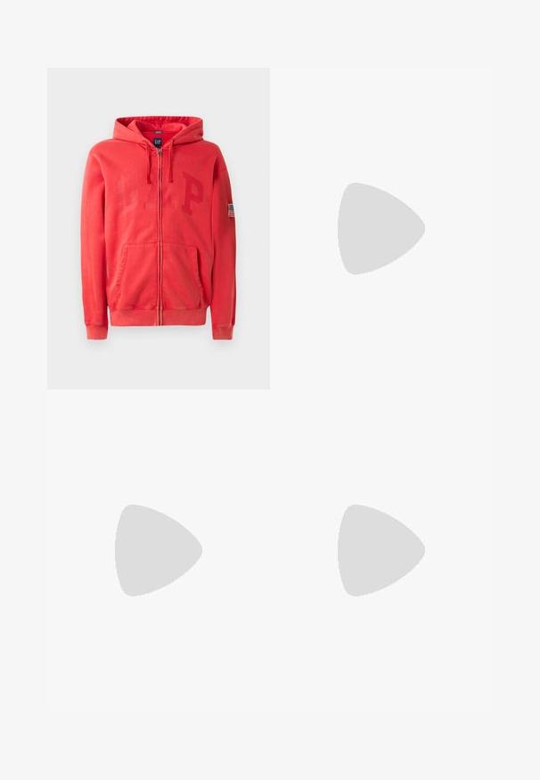 Crvena zip-up dukserica s velikim, suptilno utisnutim "GAP" logotipom na prednjem dijelu i malom oznakom američke zastave na lijevom rukavu. Materijal od pamuka i sintetičkih vlakana.; Bijela kratka majica s kratkim rukavima od pamuka s okruglim izrezom, s glatkom teksturom i jednostavnim dizajnom bez uzoraka ili naglasaka.; Crne traperice s ravnim nogavicama, s pet džepova, zatvaranjem na gumb i čistim završetkom. Trajna tkanina s mat teksturom.; Bijele kožne tenisice s sivom suknjom na vrhu, tri horizontalne bijele pruge, plavi naglasak i smeđi gumeni potplat. Tekstura na potplatu.