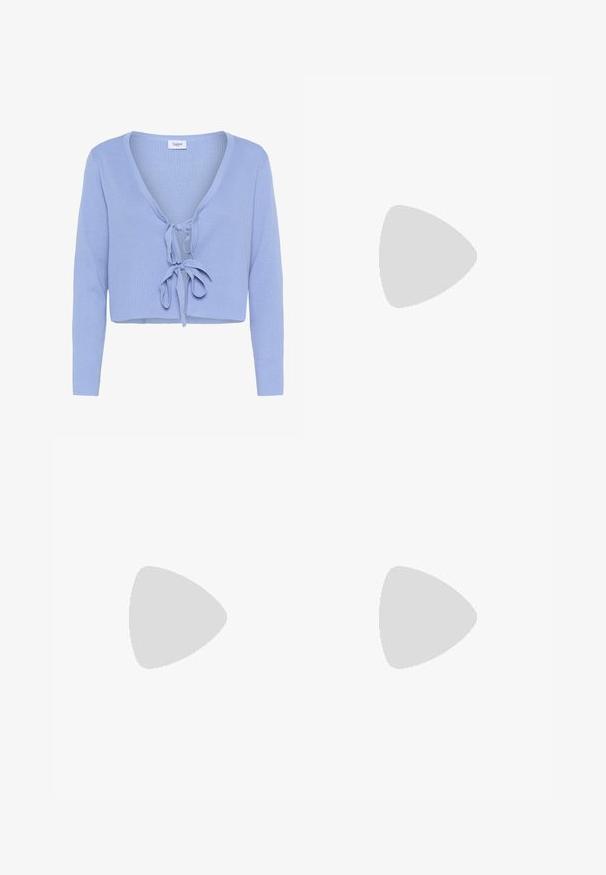 Cardigan corto azzurro chiaro con maniche lunghe, texture a coste, scollo profondo a V e chiusura con fiocco davanti. Etichetta del marchio "Saint" visibile all'altezza dello scollo.; Top bianco a coste con scollatura rotonda e senza maniche. Tessuto liscio con una silhouette aderente e senza dettagli visibili.; Jeans in denim azzurro chiaro a gamba larga con vita alta, caratterizzati da cuciture visibili e un classico design a cinque tasche. Abbinati a tacchi neri con cinturini.; Sneaker in suede marrone con dettagli e lacci bianchi. Suola in gomma color gomma. Indossati con calzini bianchi con righe nere. Pavimento verde texturizzato.; Zign LEATHER - Shopping bag - light brown