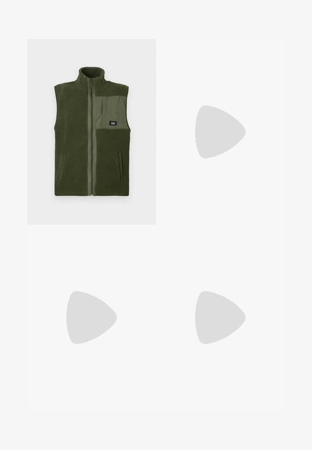 Groene fleece vest met hoge kraag, voorrits en een patchzak. Heeft een textuurstof en gladde secties, ontworpen voor warmte.; Grijze katoenen t-shirt in een blend met zwarte Nike-logo; heeft een klein Nike-label aan de zijkant bij de zoom; eenvoudig ontwerp, korte mouwen.; Beige cargobroek van lichtgewicht katoenen materiaal. Kenmerkend zijn de elastische boorden, meerdere zijzakken en een knoopsluiting.; Witte leren sneakers met perforaties, ronde neus, vlakke zool en dikke veters, met een zichtbare swoosh-logo en "AIR" op de hiel.