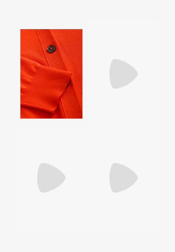 Pomarańczowy kardigan z miękką fakturą, prążkowanymi mankietami oraz czarnym guzikiem z czerwonym akcentem. Szczegółowy wzór dzianinowy na całym ciele.; Dwa bezrękawnikowe golfy w kolorze czarnym i białym, charakteryzujące się dopasowanym fasonem i gładką teksturą, o skróconej długości.; Czarne spodnie szerokie, wykonane z lekkiego materiału, z zapięciem na guzik z przodu i gładkim przodem, z starannie wykończonymi brzegami.; Buty sportowe z białą skórzaną cholewką, szarym zamszowym noskiem i trzema czarnymi paskami. Posiadają niebieskie logo na języku oraz teksturowaną gumową podeszwę.